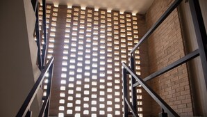 A staircase with a metal railing leading to a room with a brick wall and a patterned window. - Marvelous 2b2b Pet friendly apartment in Oaxaca “El rincon de Monde Alban” (Oaxaca)