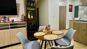 A modern kitchen with wooden cabinets, a dining area with a round table and four chairs, and a TV mounted on the wall. - Marvelous 2b2b Pet friendly apartment in Oaxaca “El rincon de Monde Alban” (Oaxaca)