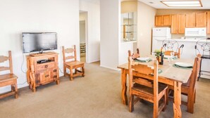 A cozy dining area with wooden furniture and a television on a stand. - 2BR Condo w/ Lake Access & Pool (Lago Vista)