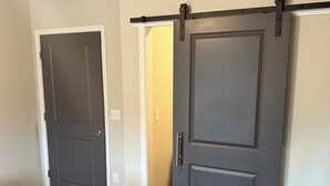 Un dormitorio con cama, armario y puerta.