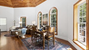 Un comedor amplio con una mesa de madera, sillas y un ventanal con vistas a zonas verdes.