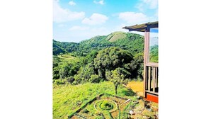 Vista de uma paisagem verdejante com um edifício que possui uma pérgola.