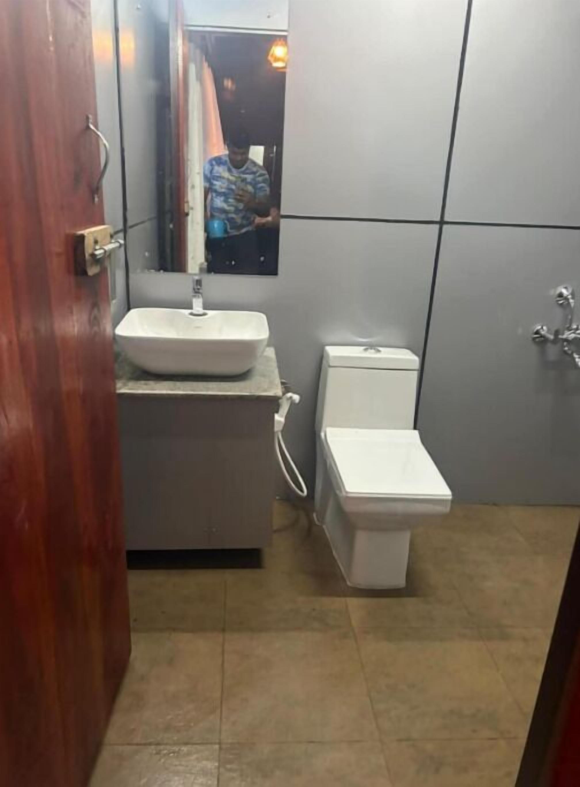 Ein Badezimmer mit einem weißen Waschbecken, einer Toilette und einem Spiegel über dem Waschbecken.