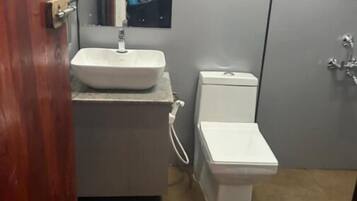 Ein Badezimmer mit einem weißen Waschbecken, einer Toilette und einem Spiegel über dem Waschbecken.
