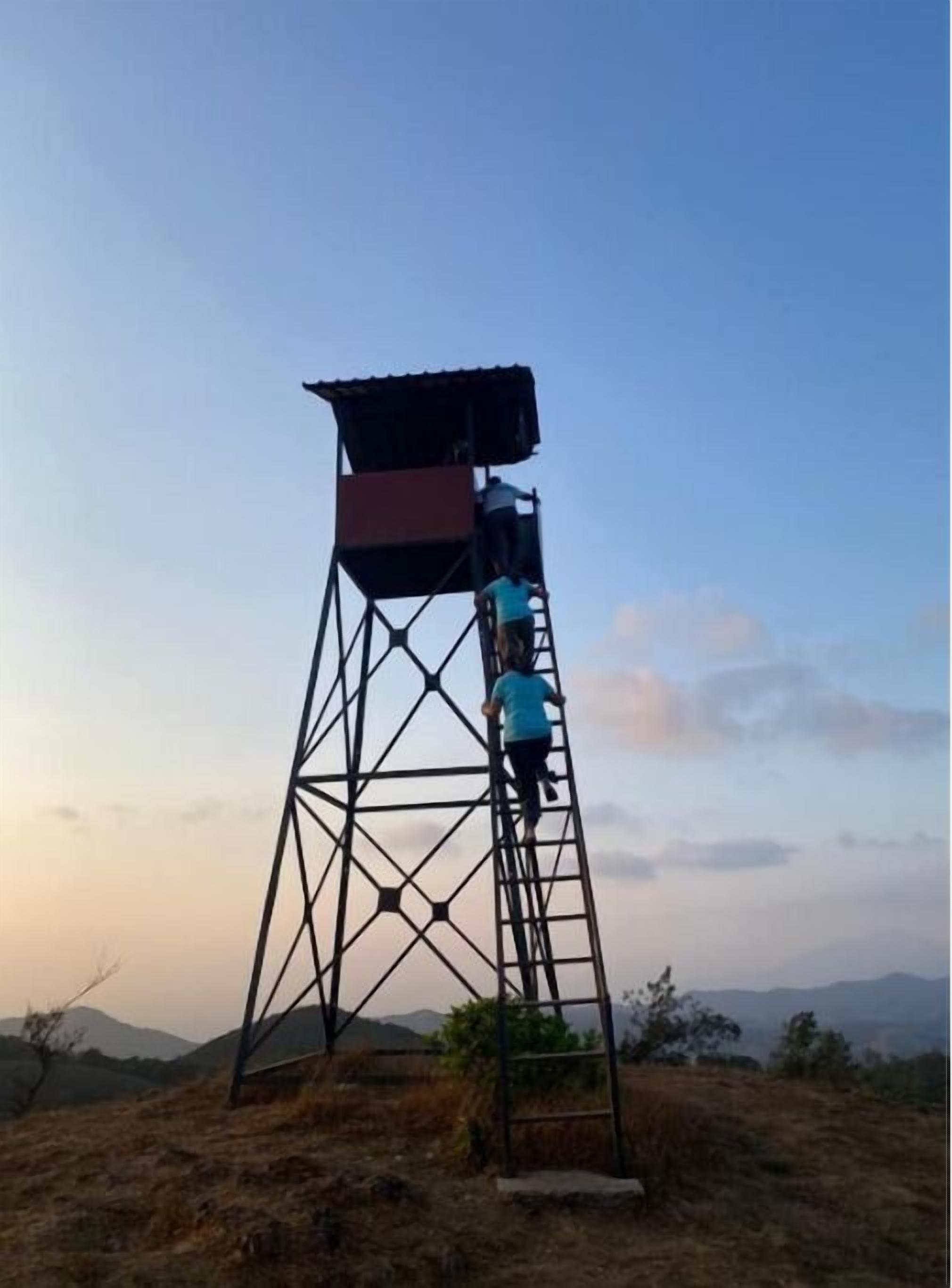 Ein hoher Metallturm mit flachem Dach und einer Leiter, die nach oben führt.