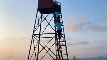 Ein hoher Metallturm mit flachem Dach und einer Leiter, die nach oben führt.