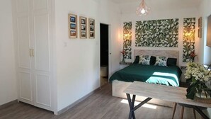 Een slaapkamer met een bed, nachtkastje, bureau en kledingkast.