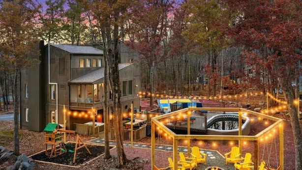 A modern building with a deck area featuring outdoor seating and a fire pit. - WOW Pocono Private Heated Pool, Pickleball, Hottub (East Stroudsburg)