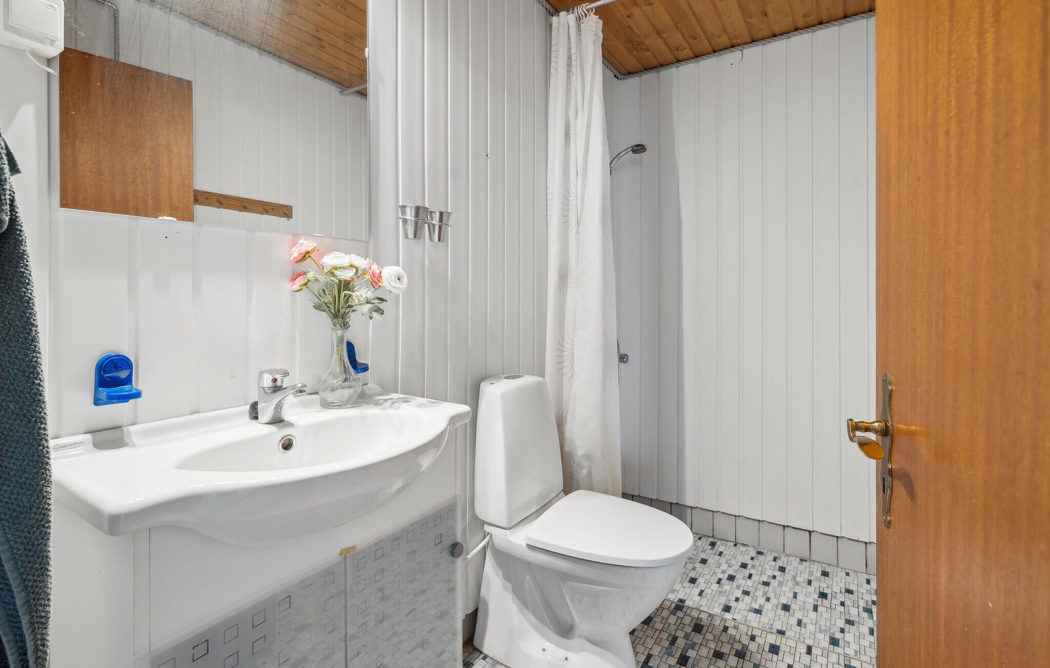 Ein Badezimmer mit weißem Waschbecken, Toilette und Duschvorhang.