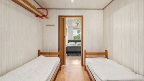 A narrow room with two beds, wooden beams, and a window leading to a balcony. - Awesome home in Sydals with WiFi (Sydals)