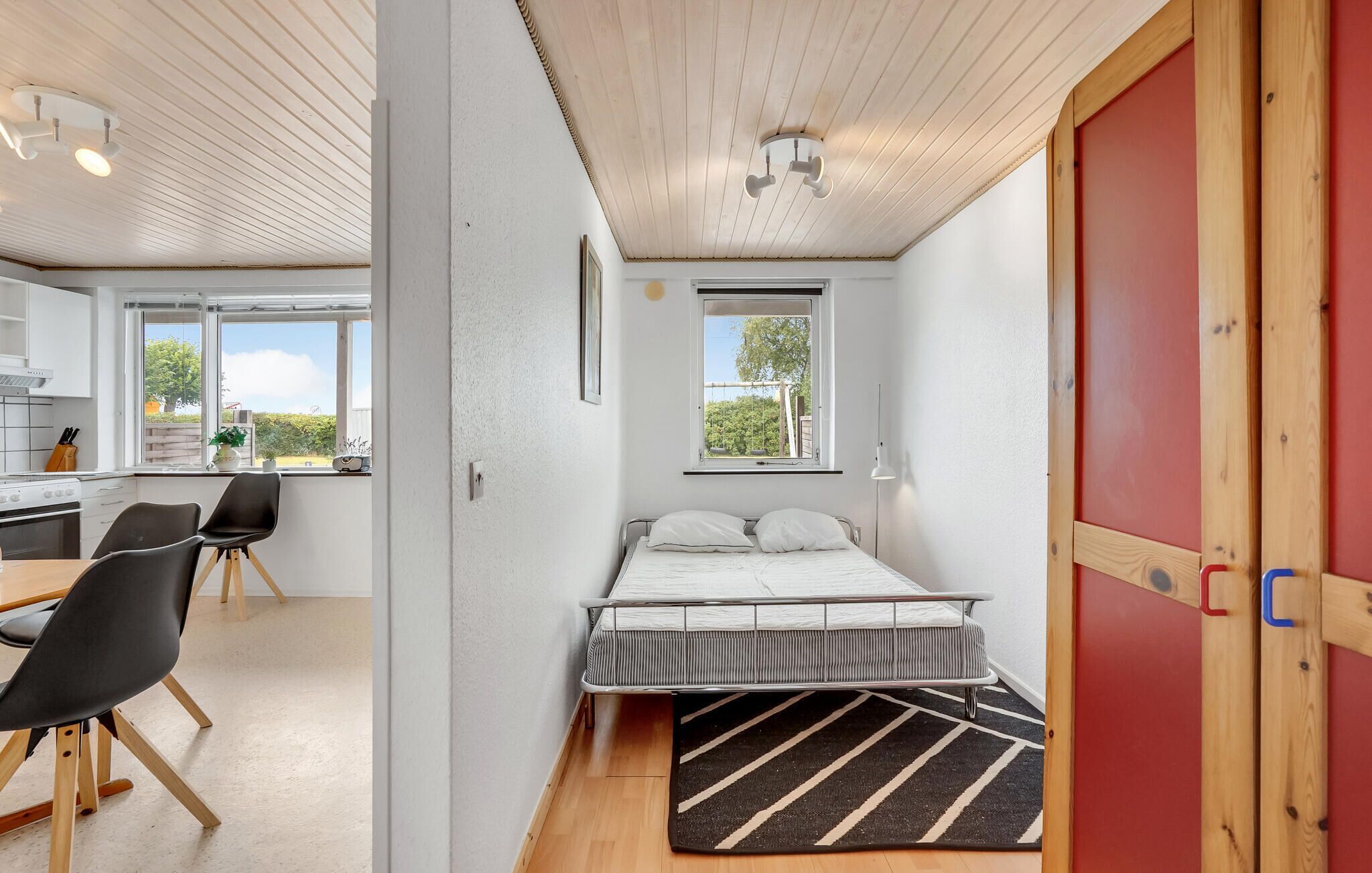 A compact bedroom with a bed, bedside table, and a window.