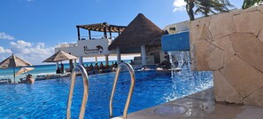 A pool area with a snack bar named 'El Pescador' and a water feature. - Beach front-Ocean View Studio -Hotel Sunset Fishermen condo 344/C (Playa del Carmen)