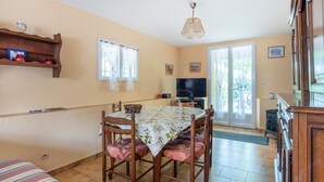 A dining area with a table set for four, a television, and a fireplace. - Beautiful home in Le Muy with WiFi (Le Muy)
