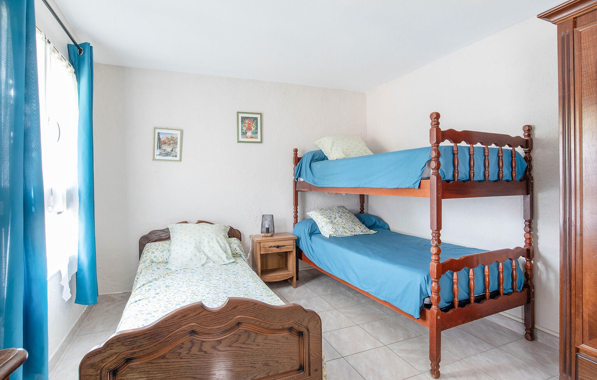 Una habitación con literas, una mesita de noche pequeña y un armario.