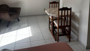 Une pièce comprenant une table à manger et des chaises, un canapé, un ventilateur de plafond et un climatiseur fixé au mur.
