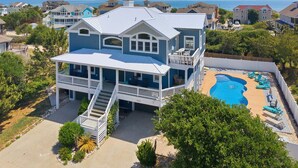 A two-story house with a balcony, a swimming pool, and a view of the ocean. - 1397 - Sunshine Stars - Corolla Escape | Saltwater Pool & Hot Tub (Corolla)