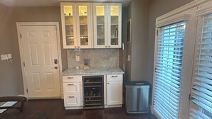 A kitchen with white cabinets, a marble countertop, and a built-in wine cooler. - Charming 2-bedroom, 2-bathroom house in peaceful Mount Rainier. (Mount Rainier)