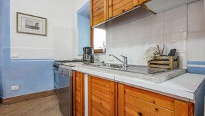 A kitchen with wooden cabinets, a stainless steel sink, and a coffee maker. - Awesome home in Roma with WiFi (Roma)