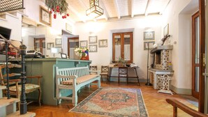 A cozy, well-lit room with a wooden floor, a bench, a dining table with chairs, a small kitchen area, and a staircase. - Gorgeous home in Roma (Roma)