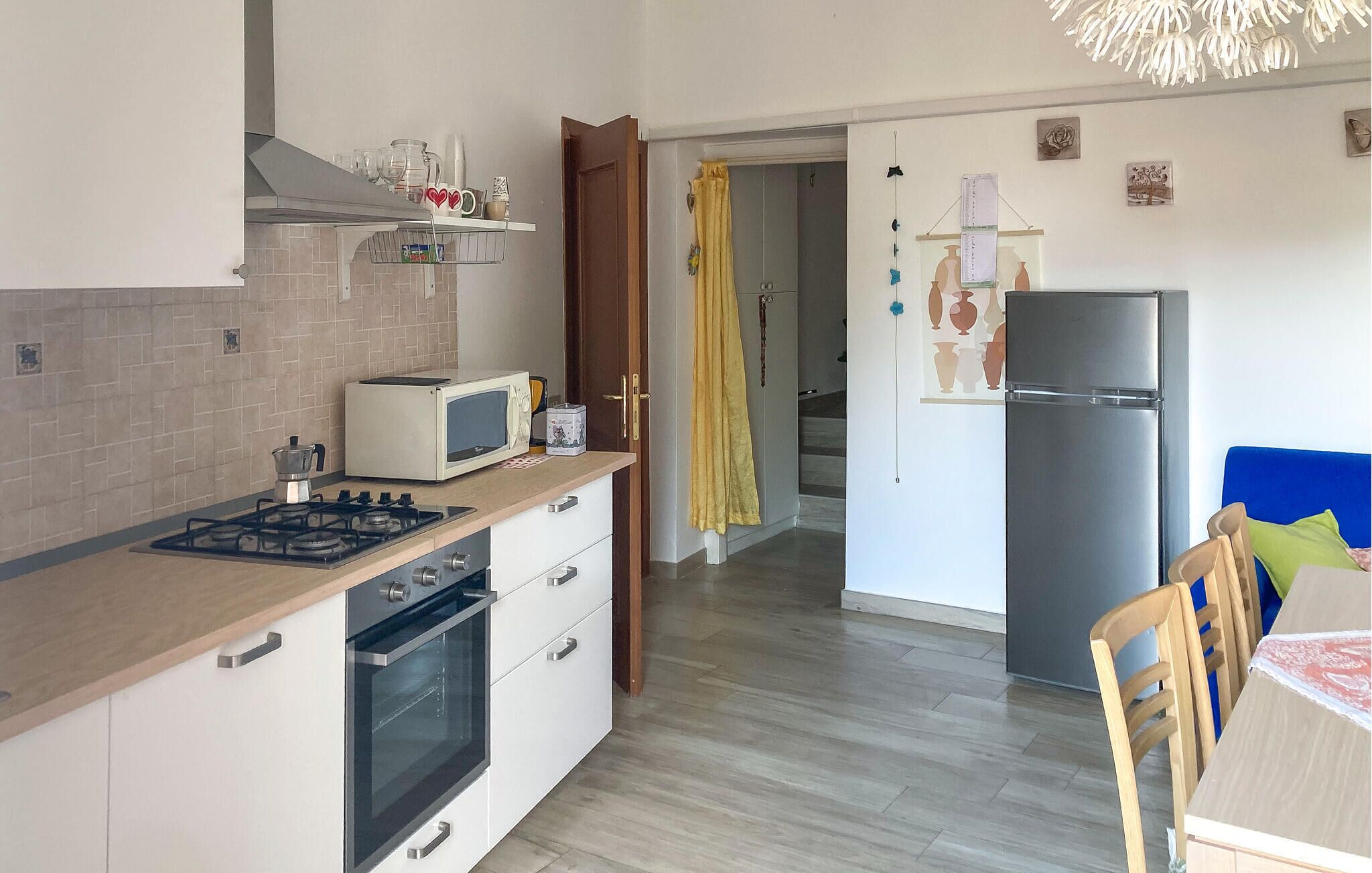A compact kitchen with a stove, microwave, oven, and refrigerator.