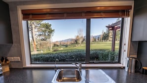 A kitchen with a large window, a sink, and a coffee maker. - Alpine Springs Motel | Hot Tub | Unit 2 - HS51212 (Hanmer Springs)