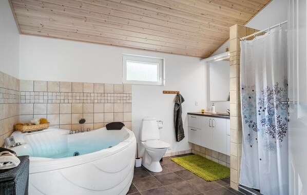 Une salle de bain avec une baignoire, des toilettes et un rideau de douche.