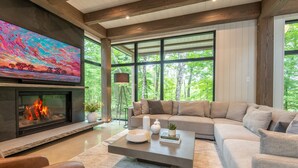 Una sala de estar moderna con chimenea, ventanas amplias y una zona de estar acogedora.