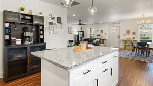 A modern kitchen with a granite countertop, dark cabinetry, and pendant lighting. - 3 bedroom, 2 bath house, sleeps 6+, baby bed W (Hood County)