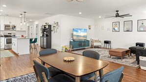 A modern living space with a dining area, kitchen, and entertainment area. - 3 bedroom, 2 bath house, sleeps 6+, baby bed W (Hood County)