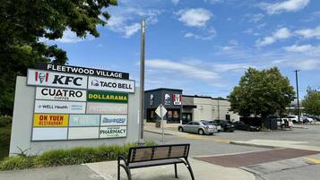 Placa listando diversos estabelecimentos, incluindo KFC, Taco Bell e Dollarama.