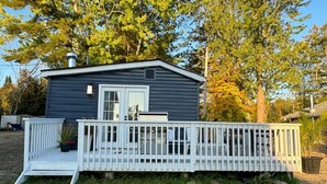 A small, single-story cabin with a white deck and a front door. - Lakefront Getaway Sparrow Lake Muskoka Beach House (Gravenhurst)