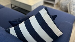 Un salon moderne avec un canapé, une table basse, un téléviseur et une lampe.