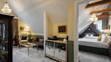 A cozy room with a bed, a sofa, a coffee table, and a mirror reflecting the room.