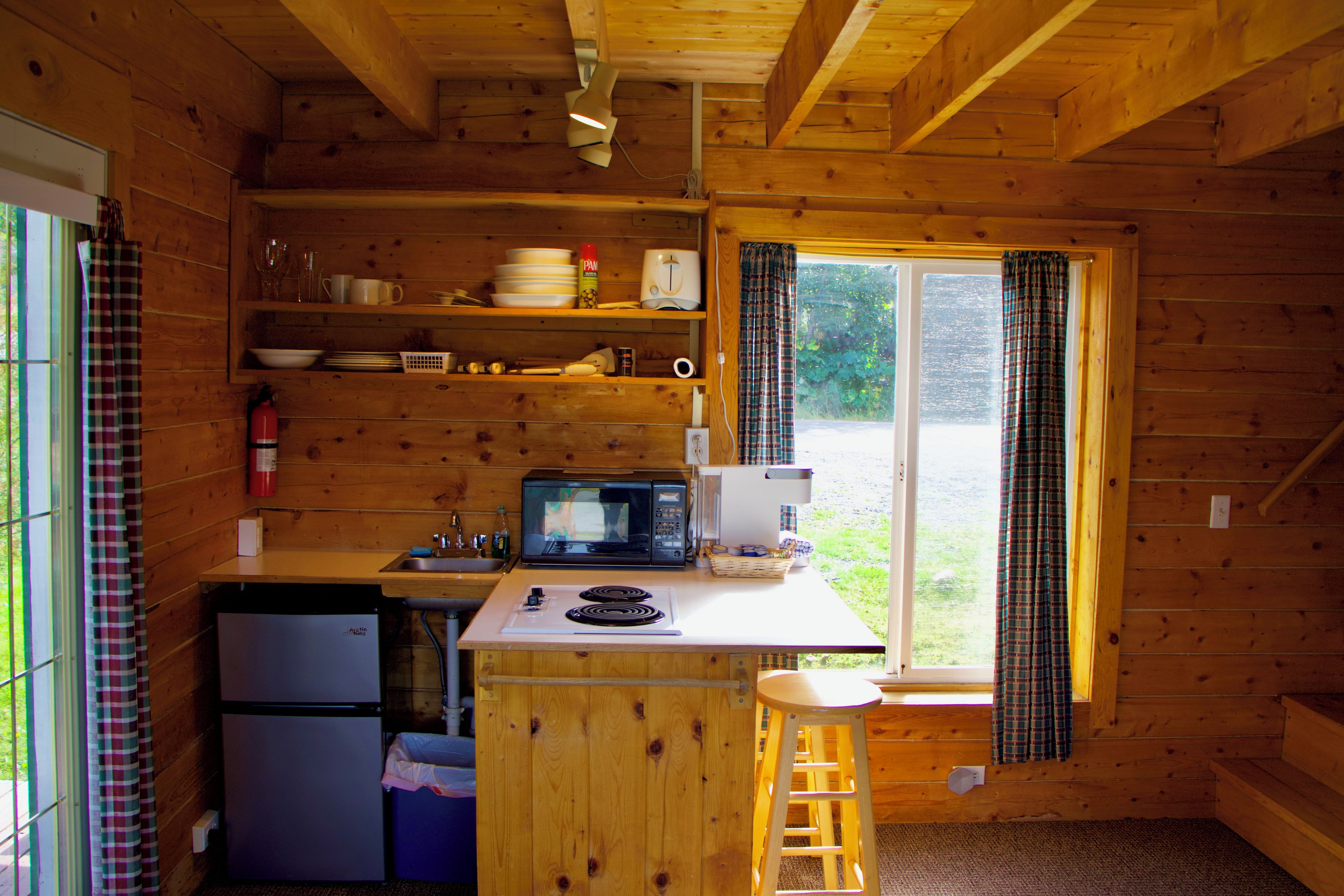 A compact kitchen with a refrigerator, microwave, and sink.