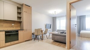 Un appartement moderne comprenant une cuisine, un coin repas et un salon.