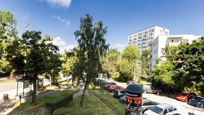 Un quartier résidentiel avec des voitures garées, un chemin et un immeuble doté de balcons.