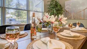 A dining table set with plates, glasses, and a floral centerpiece.