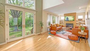 A spacious living room with a large window, a fireplace, and a cozy seating area.