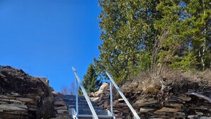 A metal staircase leading up a rocky slope.
