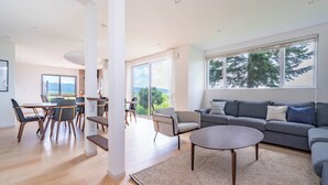 A spacious living area with a sofa, coffee table, and dining setup. - Yugen Retreats Furano (Kamifurano)