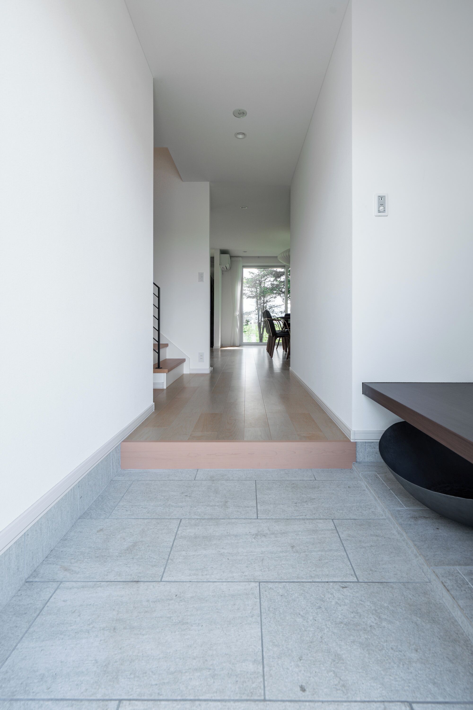 Een modern interieur met een trap naar een eetgedeelte.