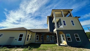 A two-story house with a balcony on the upper level, a front porch, and a garage.