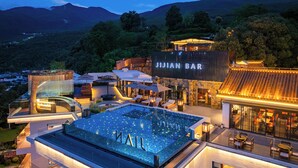 A rooftop pool with illuminated letters spelling "MALL" and a bar area with traditional architecture. - Xiangwang SOOOAN Luxury Resort Hotel (Lijiang)