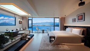 A modern hotel room with a large bed, a seating area with a view, and a desk with a computer. - Xiangwang SOOOAN Luxury Resort Hotel (Lijiang)