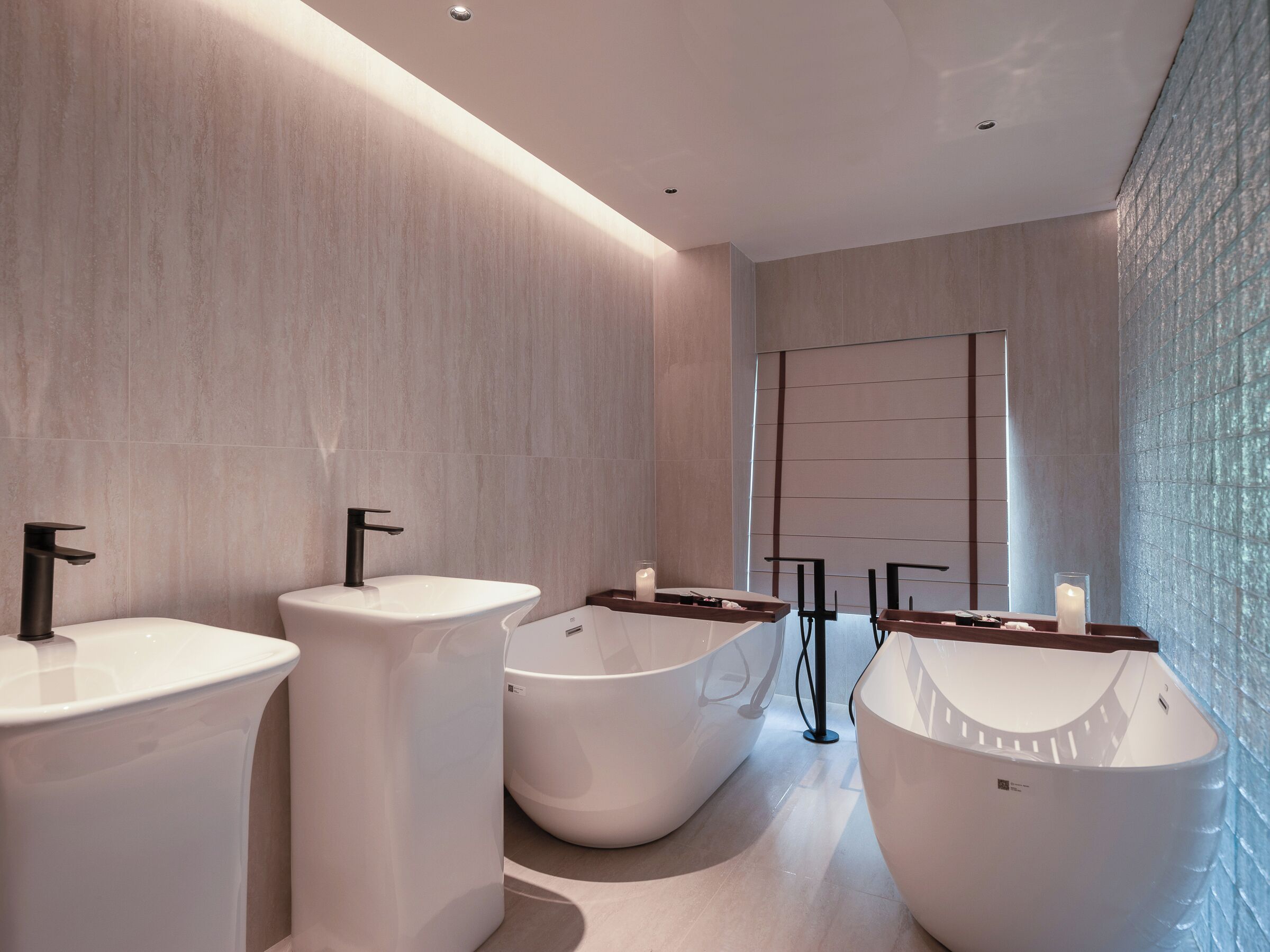 Un baño moderno con tres lavamanos blancos, una bañera grande y un espejo con marco de madera.