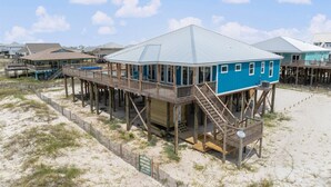 Ein Strandhaus mit Holzterrasse und überdachter Veranda.