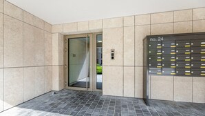 A modern elevator with a glass door, a keypad, and a digital display.