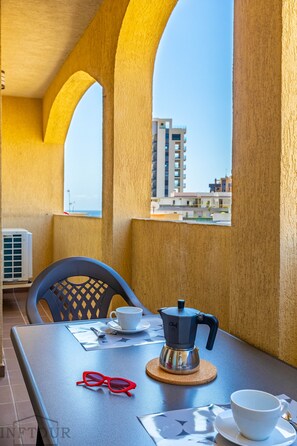 A table with a coffee maker, a cup, and a pair of sunglasses. - Inftour Medici 6L Apartamento (Calp)