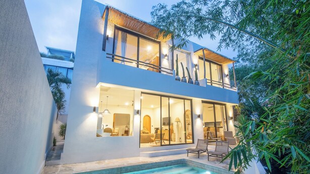 A modern two-story house with a swimming pool, large windows, and outdoor seating. - 3Br Khana in Canggu With 3 Bedrooms and 3 5 Bathrooms (Canggu)