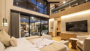 Een moderne slaapkamer met een groot bed, een televisie en een balkon met een zwembad.